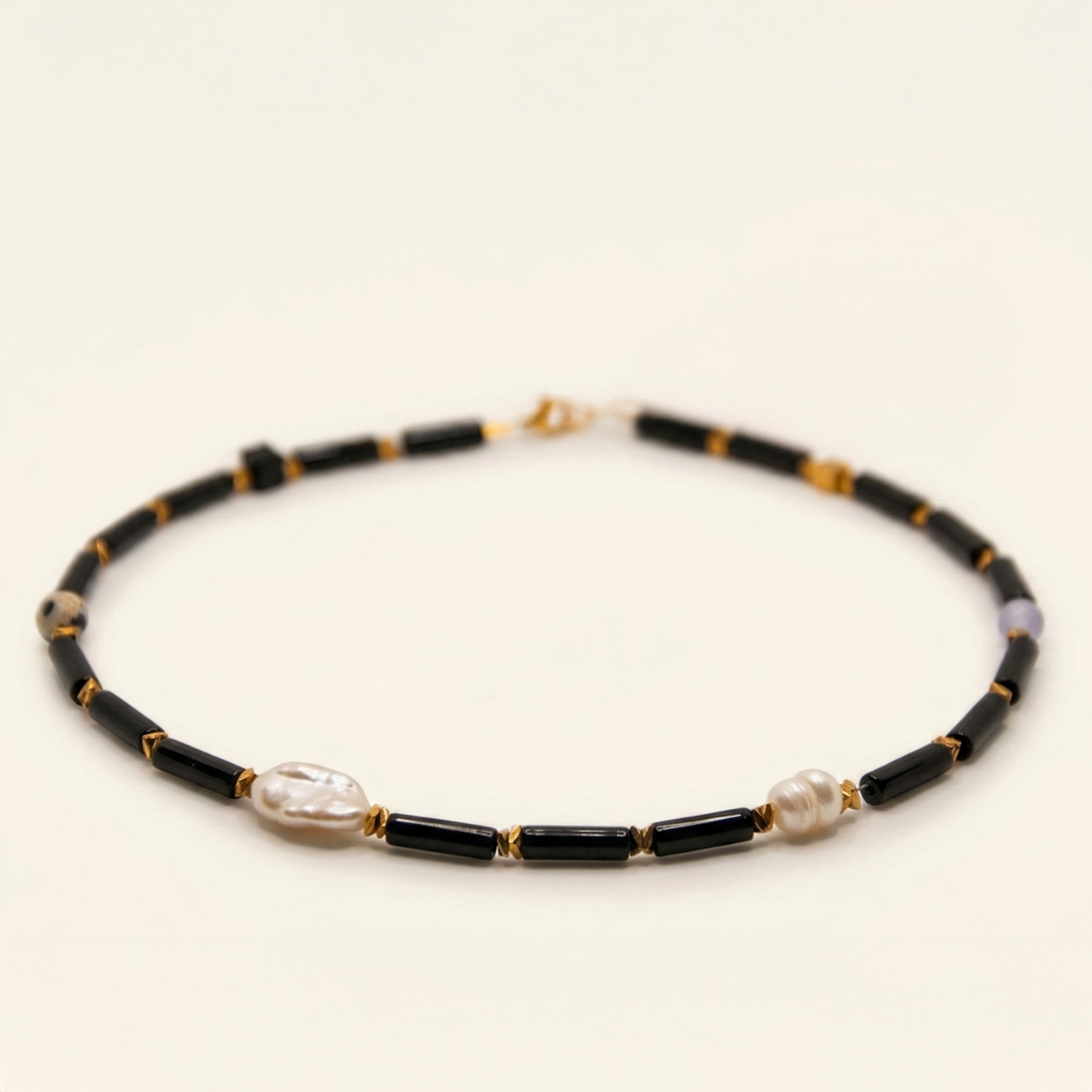 Krótki naszyjnik z kamieni: czarny turmalin, złoty hematyt, perła, jaspis dalmatyński, jadeit