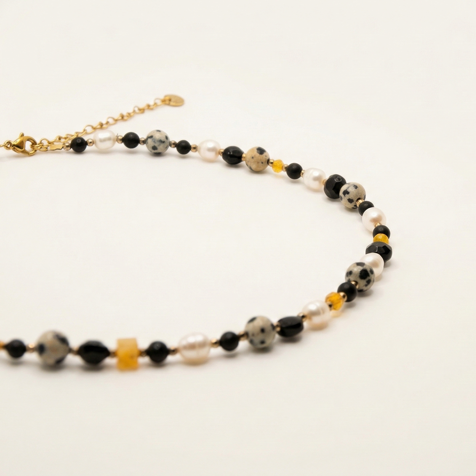 Krótki naszyjnik z kamieni: czarny agat, złoty hematyt, perła, onyks, żółta cyrkonia, jaspis dalmatyński