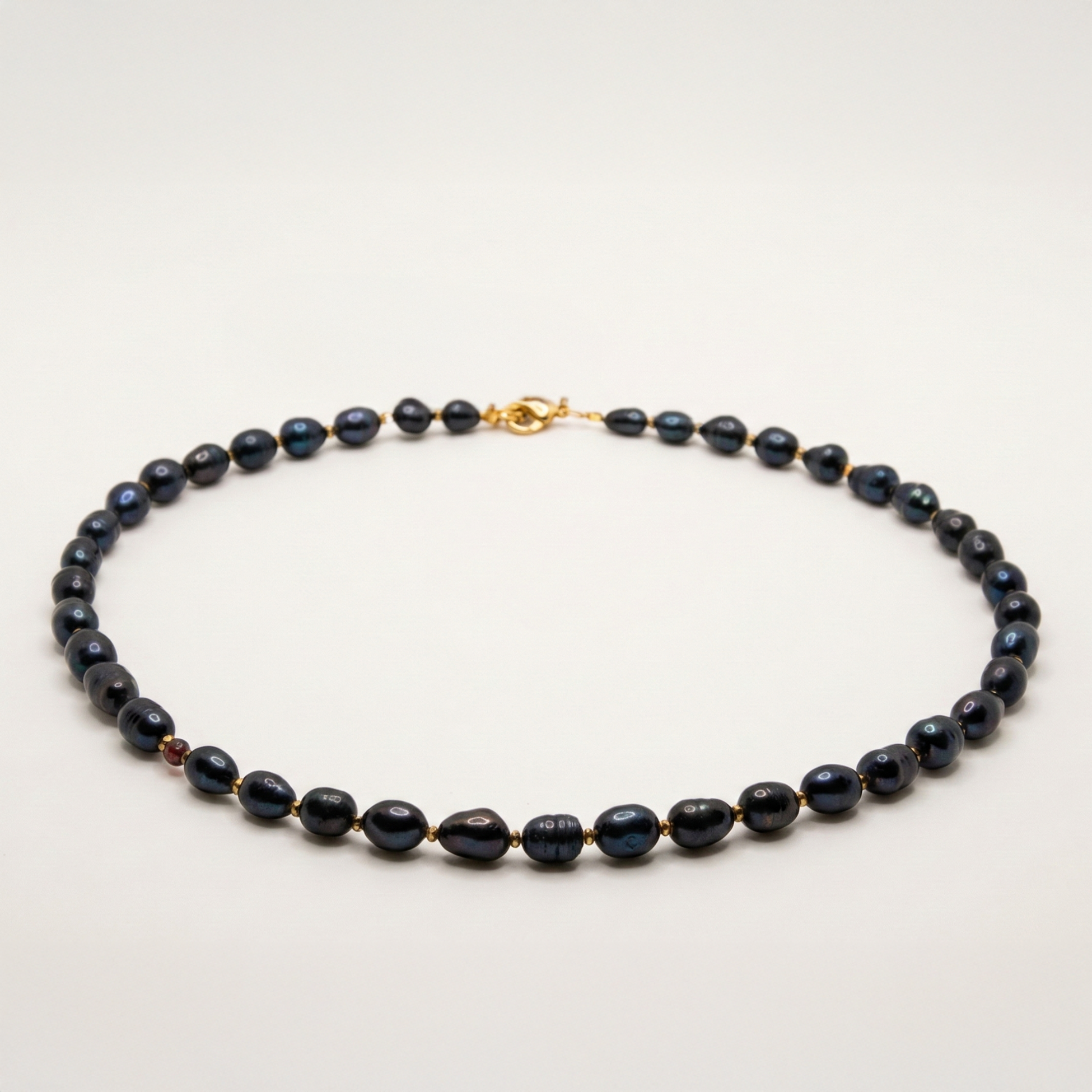 Krótki naszyjnik z kamieni: czarna perła, złoty hematyt, granat