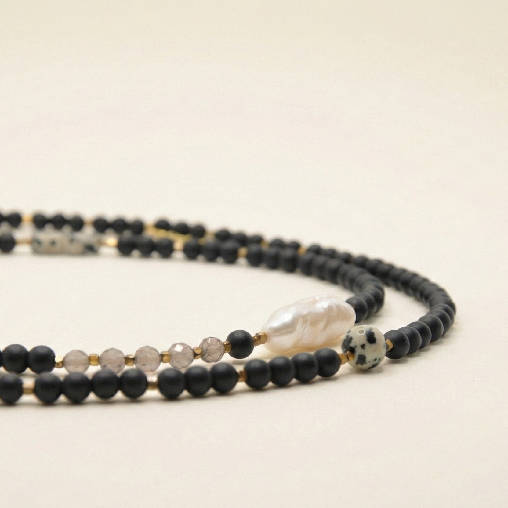 Długi naszyjnik z kamieni: czarny agat, złoty hematyt, perła, kwarc dymny, jaspis dalmatyński, kamień rzeczny