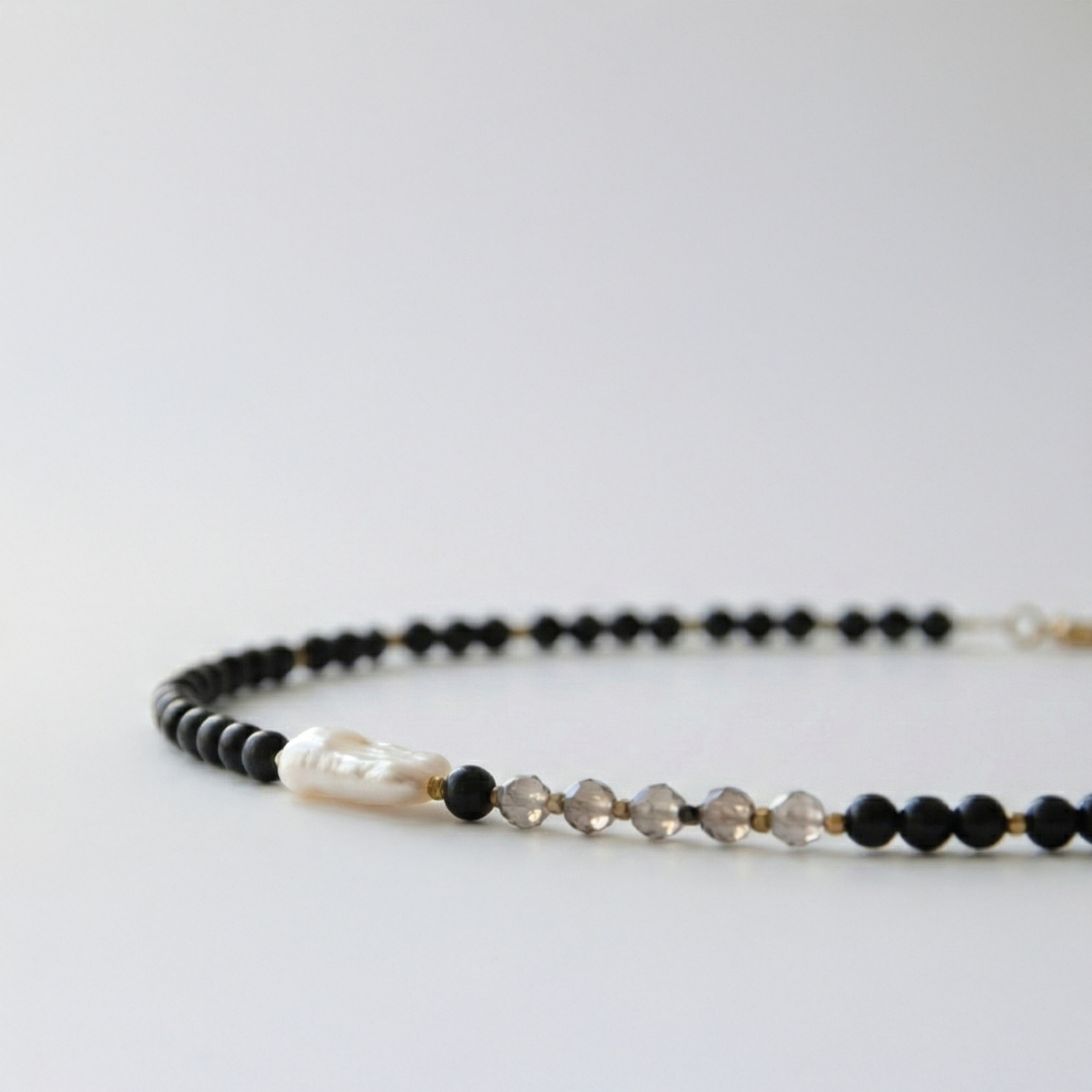 Krótki naszyjnik z kamieni: czarny agat, złoty hematyt, perła, kwarc dymny, jaspis dalmatyński