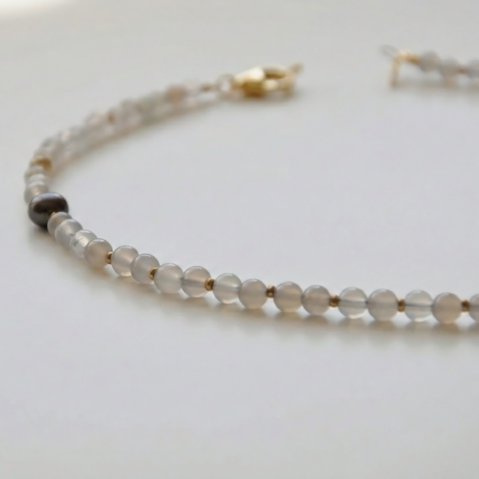 Krótki naszyjnik z kamieni: szary agat, złoty hematyt, perły