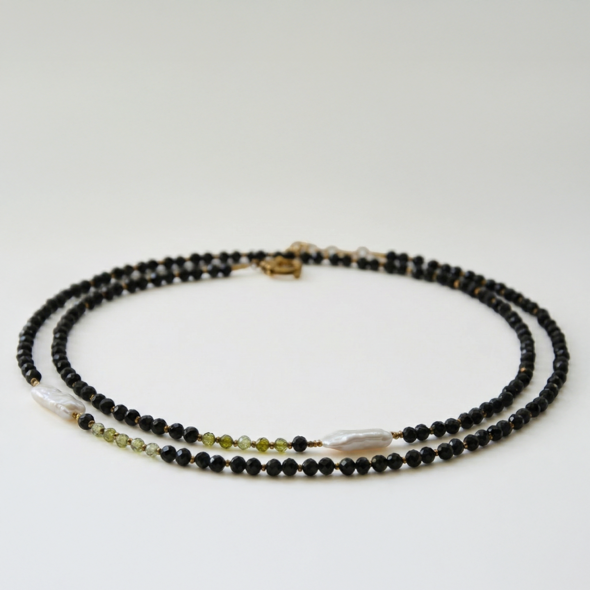 Długi naszyjnik z kamieni: czarny turmalin, złoty hematyt, zielona cyrkonia, perła