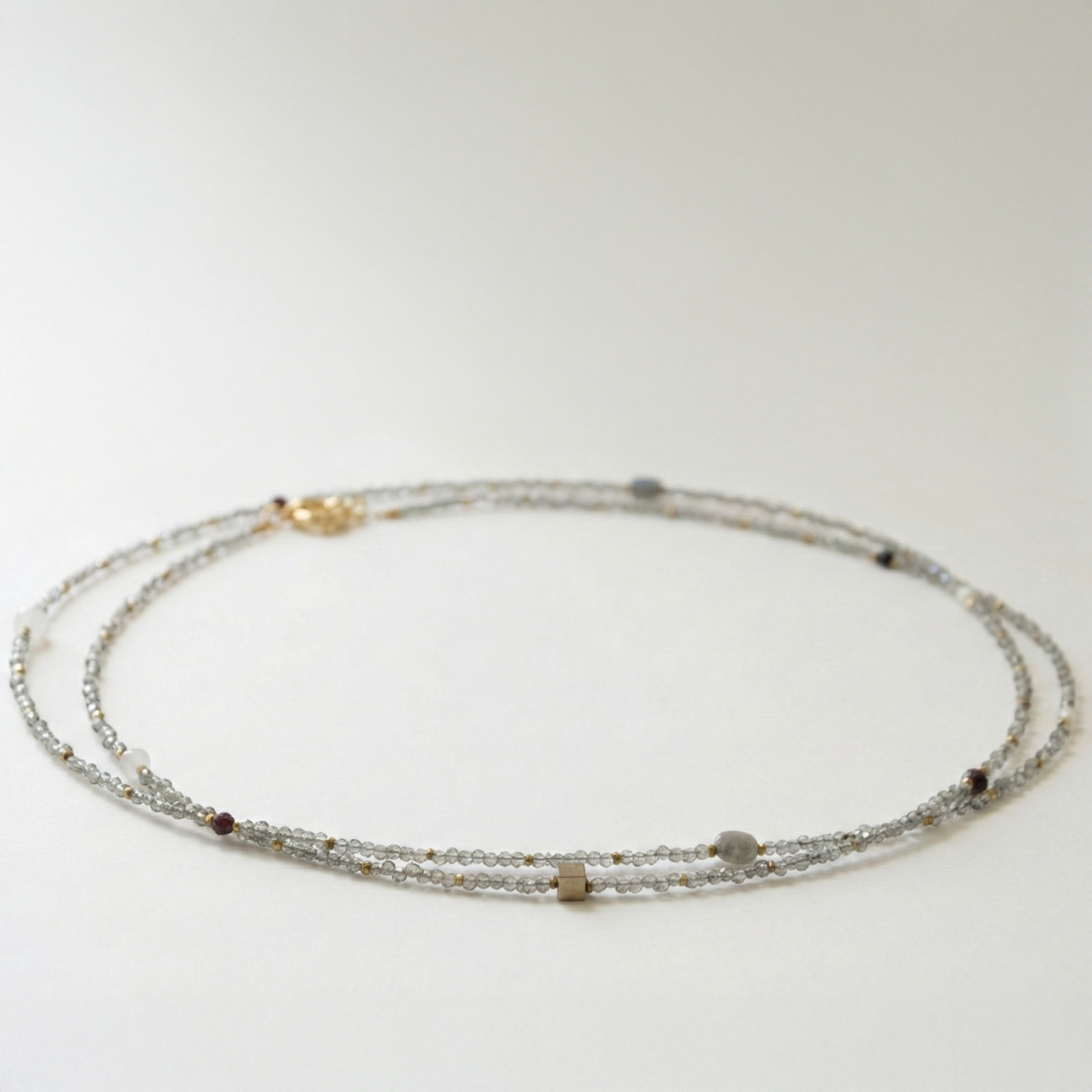 Długi naszyjnik z kamieni: cyrkonia, złoty hematyt, granat, perła, szary agat, kwarc różowy, czarny turmalin