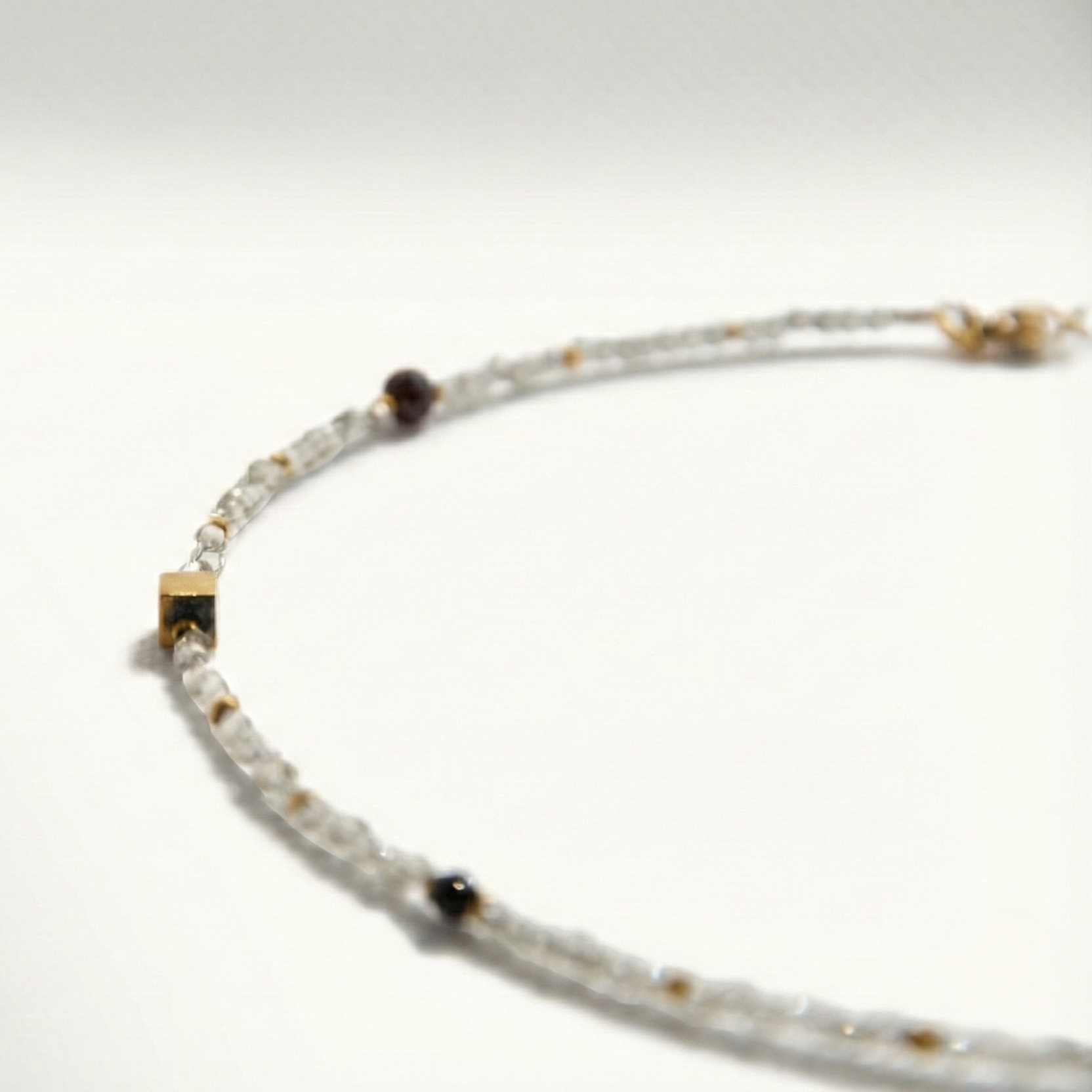 Krótki naszyjnik z kamieni: cyrkonia, złoty hematyt, granat, perła, kwarc różowy, czarny turmalin