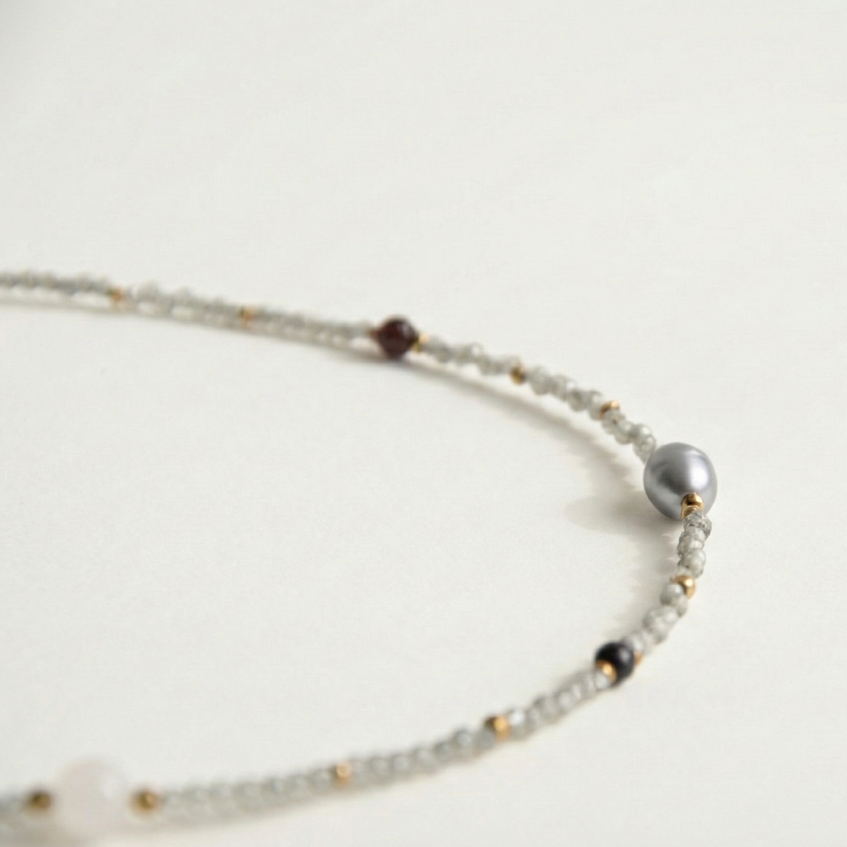 Krótki naszyjnik z kamieni: cyrkonia, złoty hematyt, granat, perła, kwarc różowy, czarny turmalin